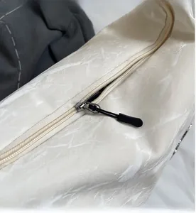 Détail de la fermeture éclair en métal noir sur le sac bandoulière à motif marbre