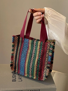 Ethnic style woven tote bag with colorful geometric patterns and red canvas handles