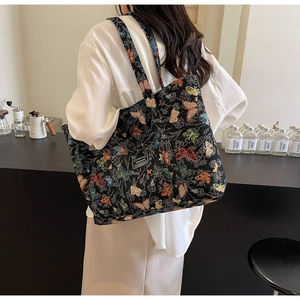 Close-up of a large canvas tote bag with colorful butterfly pattern and fashion tag