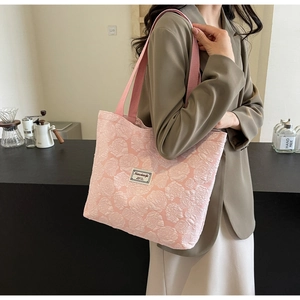 Detailed close-up of pink tote bag featuring 3D rose jacquard texture and woven strap