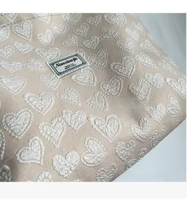 Detailed close-up of soft jacquard fabric featuring 3D heart patterns on a tote bag