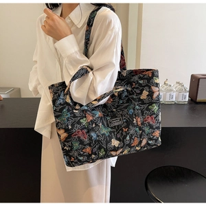 Detail of canvas tote bag featuring colorful butterfly embroidery and a fashion label