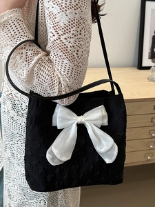Korean style black bucket bag with a large white bow and textured embossed fabric