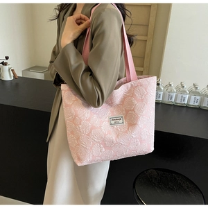 Detailed close-up of pink floral jacquard tote bag with textured flower pattern and strap