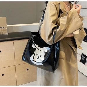 Detail of cute rabbit print on a black large capacity PU leather tote bag worn by a model