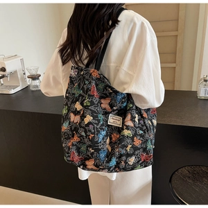 Detailed close-up of colorful butterfly jacquard embroidery on large black canvas tote bag