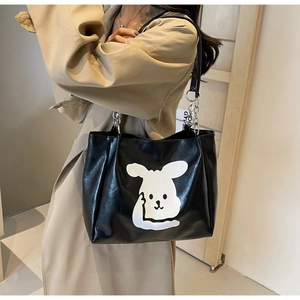Detailed view of black PU tote bag with cartoon pattern and silver metal chain strap