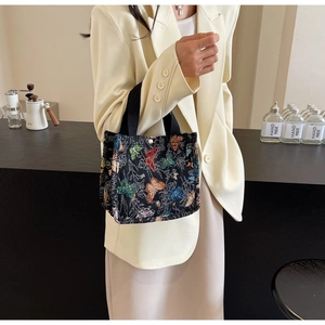 Detail of canvas tote bag featuring colorful butterfly patterns and magnetic closure