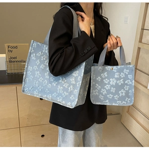Blue jacquard tote bag set with white floral pattern on a wide shoulder strap