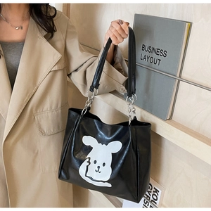 Detail of cartoon animal print on large black PU tote bag with silver chain straps
