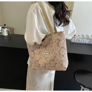 Detail of rose jacquard texture on coffee brown tote bag with woven shoulder straps