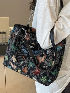 Fashionable butterfly jacquard tote bag with chain strap shown on model's shoulder