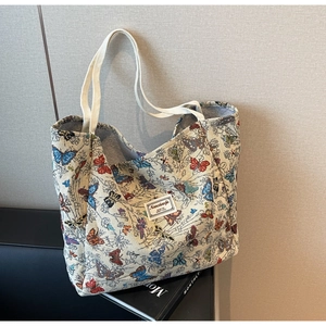 Close-up of butterfly jacquard pattern on large canvas tote bag with brand label