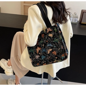 Close-up of colorful butterfly jacquard tote bag with wide black woven strap