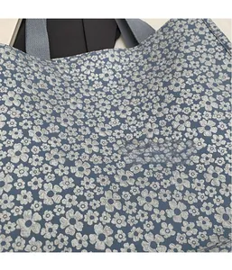 Vue détaillée du sac cabas en jacquard gris avec broderies florales argentées complexes