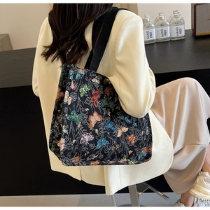 Detail of a large capacity tote bag featuring vibrant butterfly patterns on black fabric