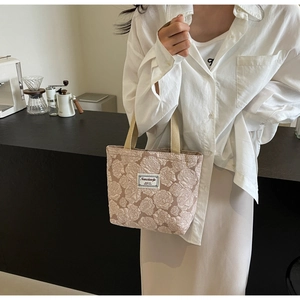 Detailed shot of pink floral jacquard fabric and beige canvas straps on a mini tote bag
