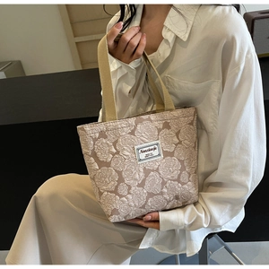 Detailed close-up of 3D rose floral embossed texture on the beige canvas tote bag