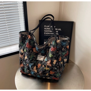 Detail of the butterfly jacquard fabric texture on a large black canvas tote bag