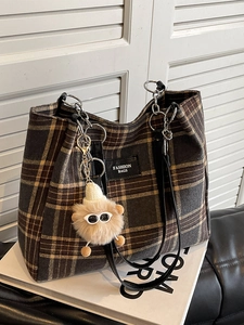 Retro plaid tote bag with chain strap and plush monster pendant on white background