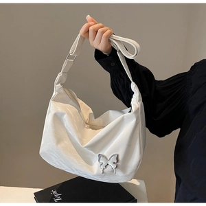 Détail du sac bandoulière blanc plissé avec boucle papillon argentée et sangle réglable