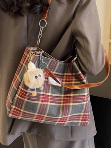 Classic red plaid tote bag with plush charm and brown straps for casual daily use