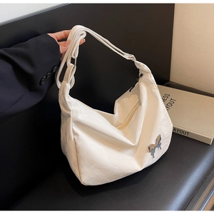 Détail du sac en similicuir blanc avec une boucle papillon en métal argenté brillant