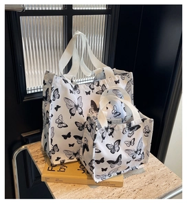 Detail of white butterfly print canvas tote bag set including large and small shopping bags