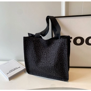Detail of black tote bag featuring unique 3D bubble textured fabric and reinforced handles