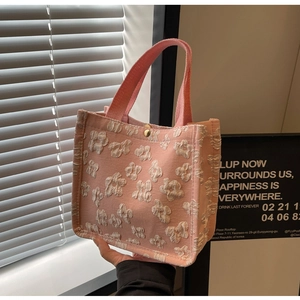 Detail of pink canvas tote with 3D floral embroidery and gold magnetic buckle closure