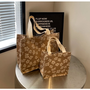 Detail of floral jacquard canvas tote bag set with textured white flowers and woven handles