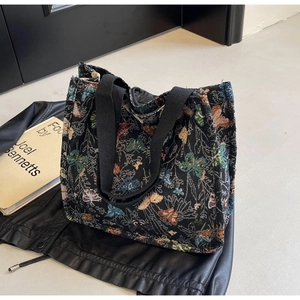 Close-up of colorful butterfly embroidery on a black canvas tote bag for women