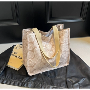 Détail du sac cabas en jacquard floral avec texture de rose et poignée tissée sur cuir