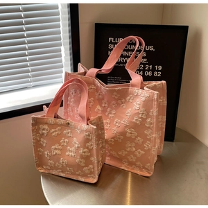 Detail of pink tote bags with 3D floral texture and golden magnetic buckle closure