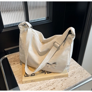 Détail du sac à bandoulière en nylon blanc plissé avec ornement papillon en métal argenté