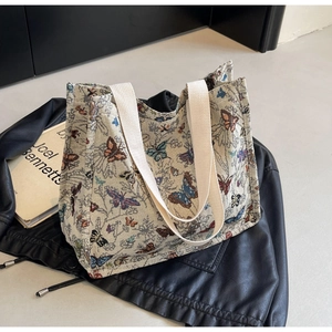 Close-up of the butterfly jacquard fabric and canvas straps on this large tote bag