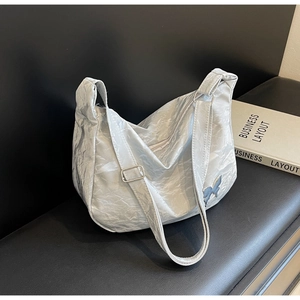 Détails du sac bandoulière argenté plissé avec patchs papillon et texture métallique