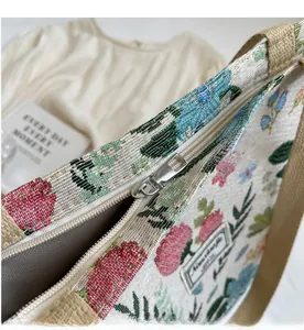 Close-up of smooth silver metal zipper and floral canvas pattern on tote bag detail
