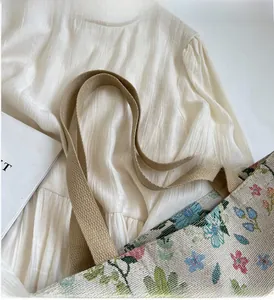 Detail of floral jacquard tote bag featuring colorful flower patterns and woven handles