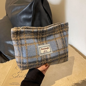 Detail of blue and brown checkered wool pouch showing soft texture and brand label