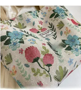 Close-up of floral jacquard texture on beige canvas tote bag with woven flower pattern