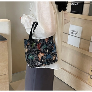 Detail of vintage butterfly pattern on large capacity tote bag with woven handles