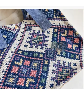 Macro shot of ethnic pattern woven fabric and canvas handle with gold metal rivet