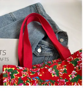 Detail of red floral canvas tote with traditional peony pattern and sturdy handles