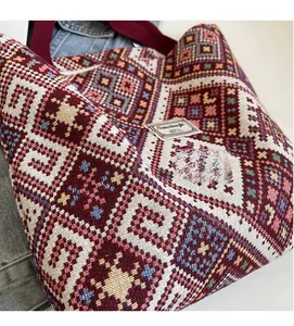 Détail du tissage géométrique ethnique d'un grand sac cabas en toile avec sangle rouge