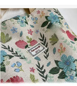 Close-up of floral jacquard fabric on the tote bag showing complex woven textures