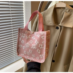 Detailed view of pink tote bag featuring white 3D floral textures and golden fastener