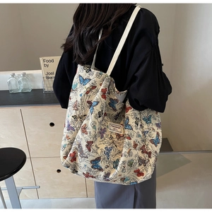 Detail of the high-capacity canvas tote bag featuring colorful butterfly patterns and strap