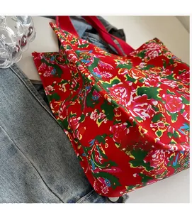Detail of red floral tote bag featuring traditional peony phoenix pattern on canvas fabric