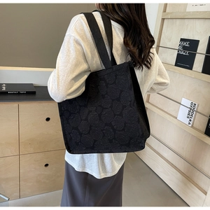 Détail du sac cabas noir avec texture jacquard en relief de roses florales 3D
